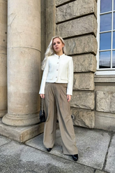 a lady in a white top and a pair of brown wide leg pants